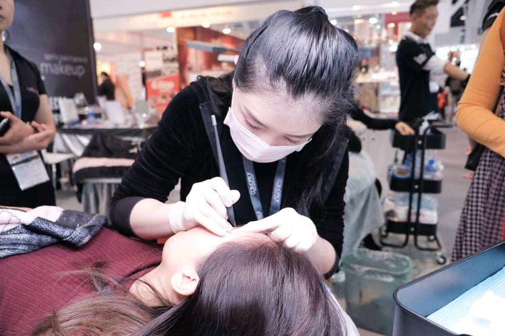Applying permanent eyebrows at an event. Applying permanent eyebrows at an event.