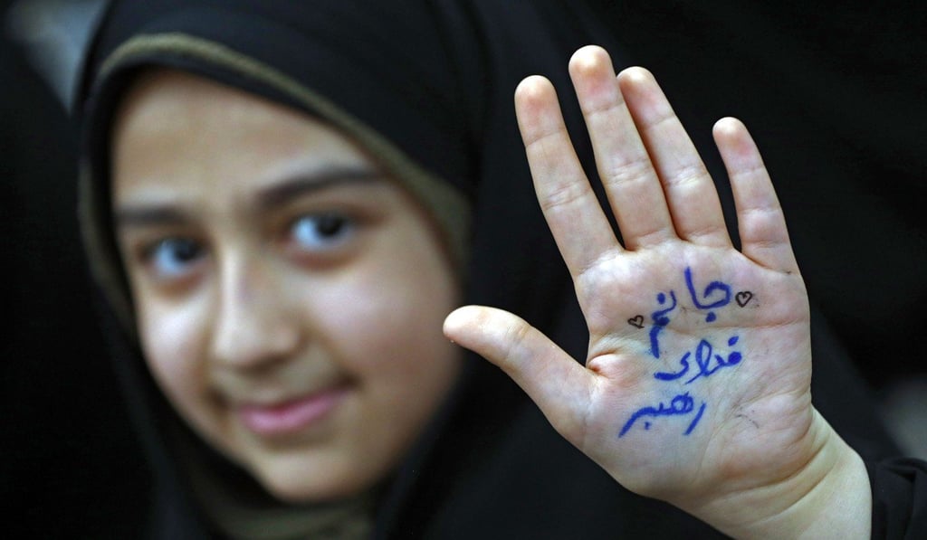 An Iranian girl shows her hand with a slogan reading in Farsi: “Ready to sacrifice my self for the leader” at Khomeini’s tomb on Friday. Photo: AFP