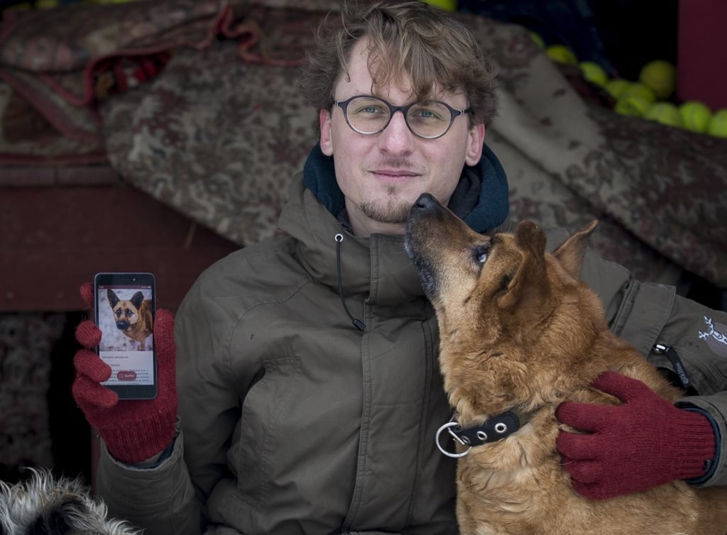 Vaidas Gecevicius showing the profile of the dog next to him on the app, which he helped to create. Photo: AP
