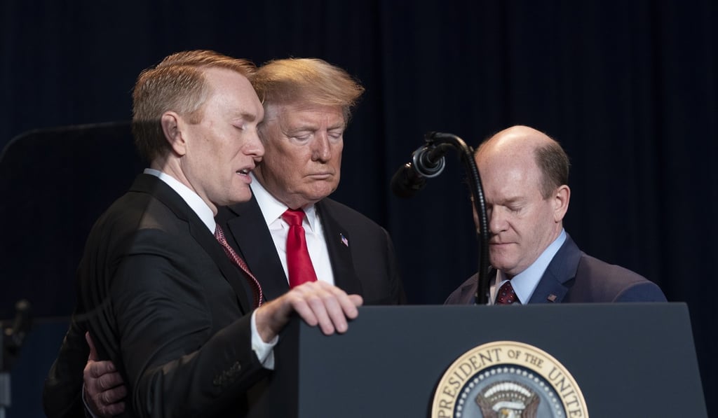 From left, US Republican Senator James Lankford, President Donald Trump and Democratic Senator Chris Coons pray at the 2019 National Prayer Breakfast in Washington on Thursday. Photo: EPA