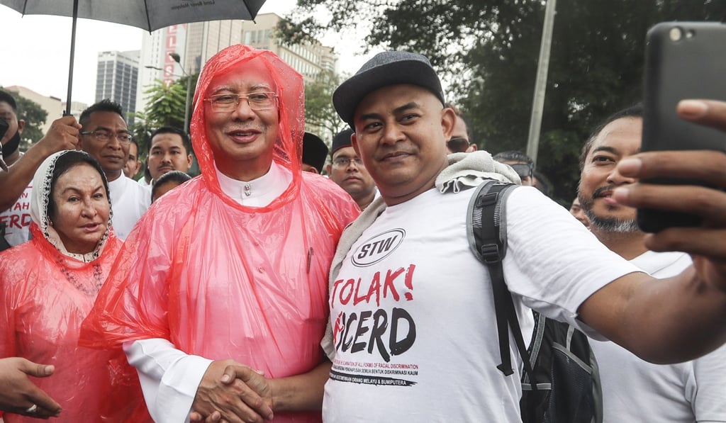 A supporter takes a selfie with Najib Razak, centre, and his wife, Rosmah Mansor, left, during a rally in Kuala Lumpur in December. Photo: EPA