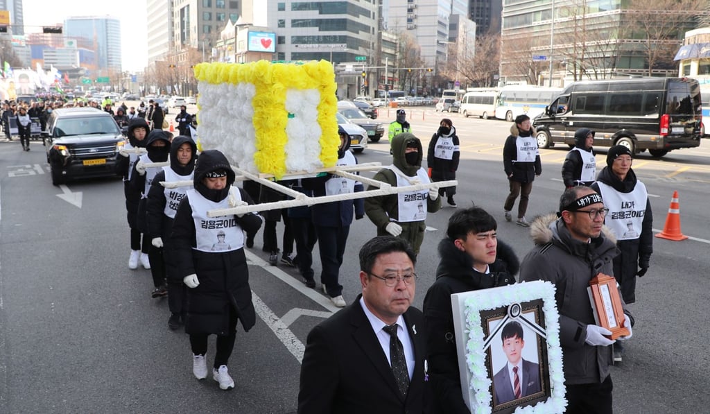 People march to honour a worker crushed to death at a coal plant. Photo: AFP