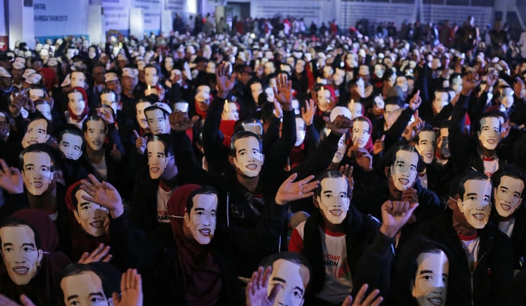Supporters wave as they wear masks depicting Indonesian President Joko Widodo during a rally in Bogor, West Java, Indonesia, in November last year. Photo: AP