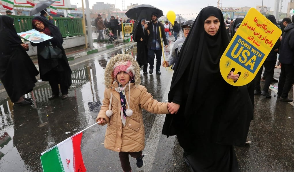 An Iranian woman carrying a sign saying ‘Down with USA’. Photo: AFP