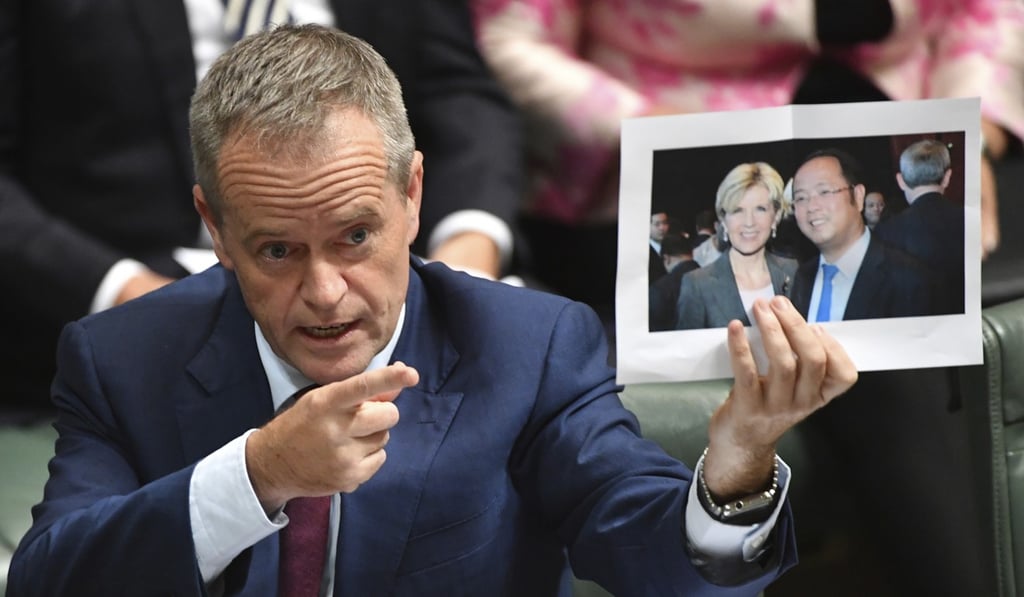 Bill Shorten holds a photograph of former foreign minister Julie Bishop and Chinese businessman Huang Xiangmo. Photo: AP Bill Shorten holds a photograph of former foreign minister Julie Bishop and Chinese businessman Huang Xiangmo. Photo: AP