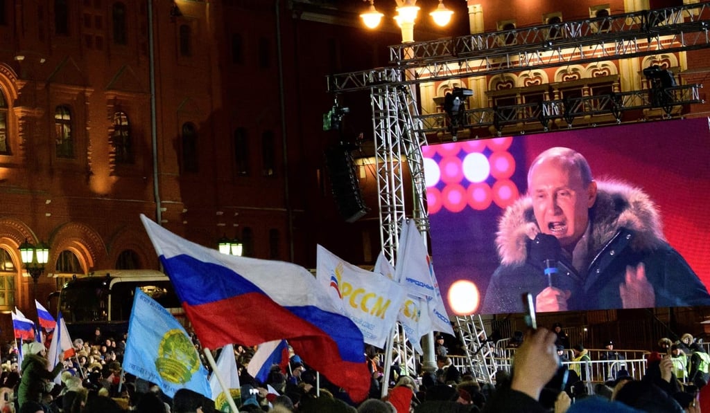 People listen to President Vladimir Putin during a rally and a concert celebrating the fourth anniversary of Russia's annexation of Crimea at Manezhnaya Square in Moscow in March 2018. Photo: AFP