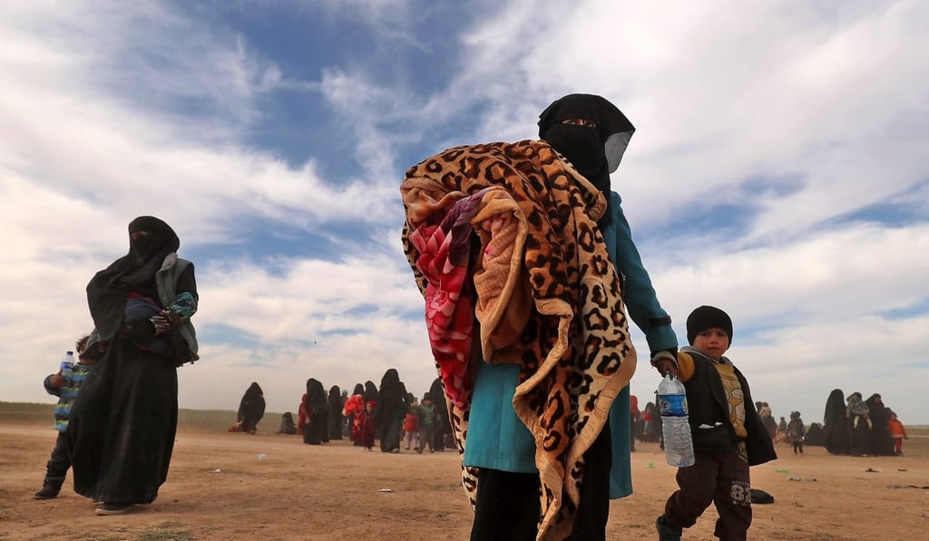 Fully veiled women walk with their children as civilians fleeing the Islamic State's group embattled holdout of Baghouz gather in a field on February 13, 2019 during an operation by the US-backed Syrian Democratic Forces (SDF) to expel the Islamic State group from the area, in the eastern Syrian province of Deir Ezzor. Photo: AFP Fully veiled women walk with their children as civilians fleeing the Islamic State's group embattled holdout of Baghouz gather in a field on February 13, 2019 during an operation by the US-backed Syrian Democratic Forces (SDF) to expel the Islamic State group from the area, in the eastern Syrian province of Deir Ezzor. Photo: AFP
