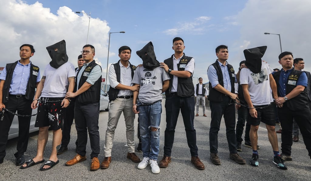 Mainland police hand over three robbery suspects to their Hong Kong counterparts through an informal arrangement. Photo: Edward Wong