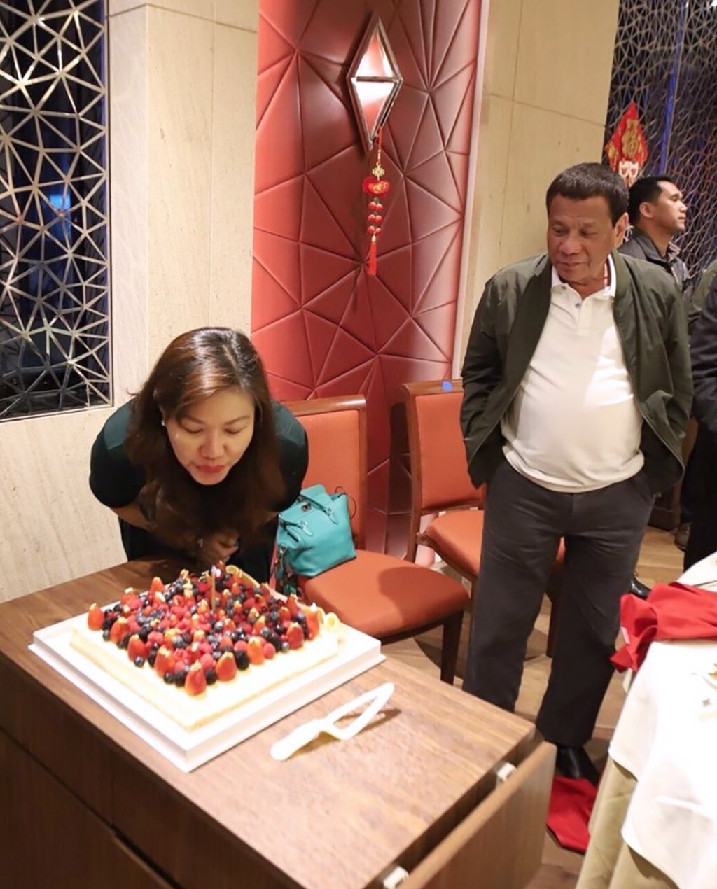 Honeylet Avancena blows out the birthday cake candles as Rodrigo Duterte looks on. Photo: Twitter