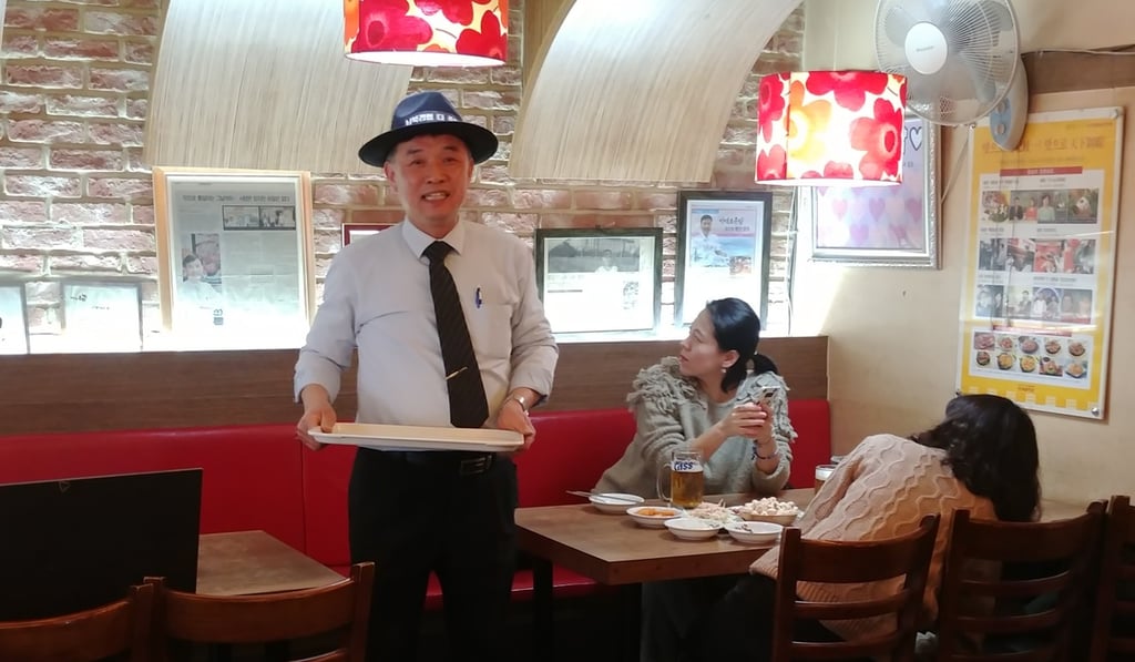 Choi Won-ho, wearing a hat inscribed with a slogan calling for compensations for his lost investment in North Korea, at his restaurant in Seoul. Photo: Park Chan-kyong