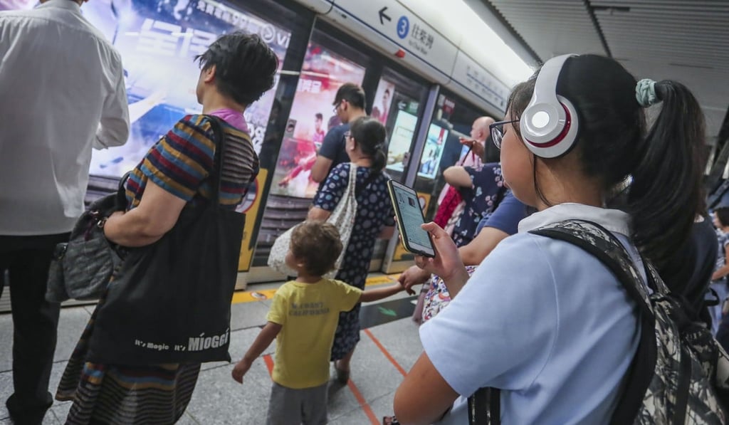 A Hong Kong student uses her smartphone while waiting for the MTR. Photo: Jonathan Wong