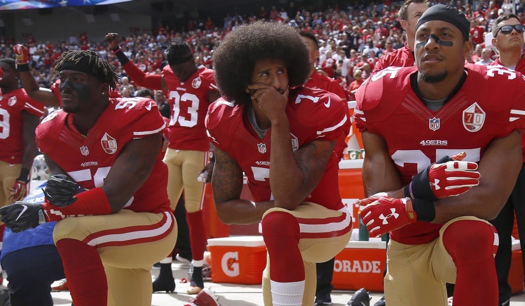 Colin Kaepernick and Eric Reid (left) sent the football world into a political tailspin by kneeling during the national anthem. Photo: TNS