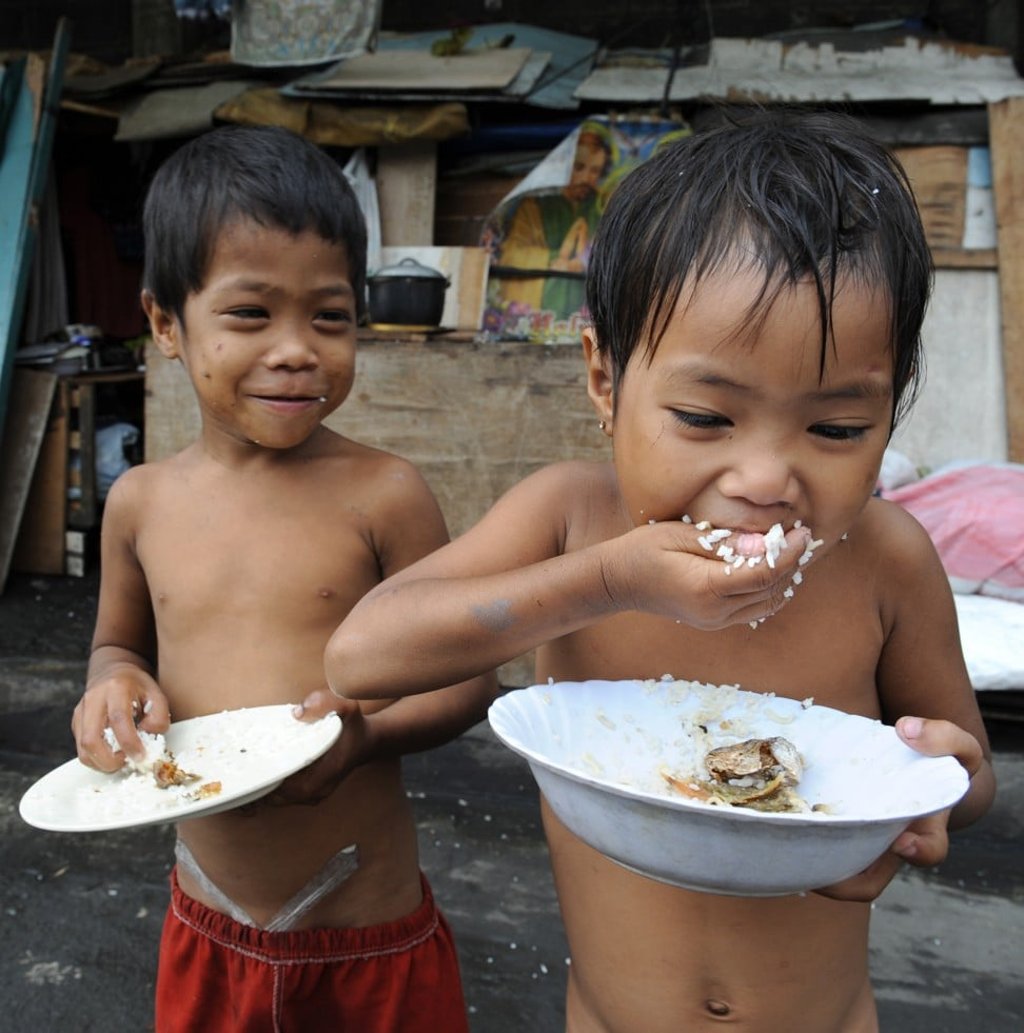 Philippine children eat a meal of rice mixed with noodles and dried fish. Photo: AFP