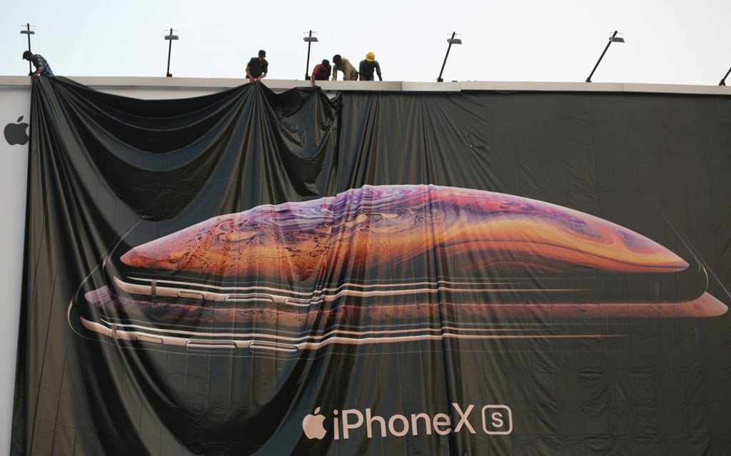 Workers adjust a billboard advertisement for the newly launched Apple iPhone XS in Ahmedabad, India, in October 2018. Photo: Reuters