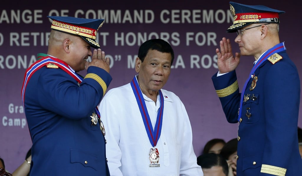 Philippine President Rodrigo Duterte (centre) looks on as the new chief of the Philippine National Police Director-General Oscar Albayalde (right) and outgoing chief General Ronald “Bato” Dela Rosa salute each other at a ceremony on April 19, 2018, at Camp Crame in Quezon City, Philippines. Duterte, in his address, said he would not stop his war on drugs until his last day in office. Photo: AP