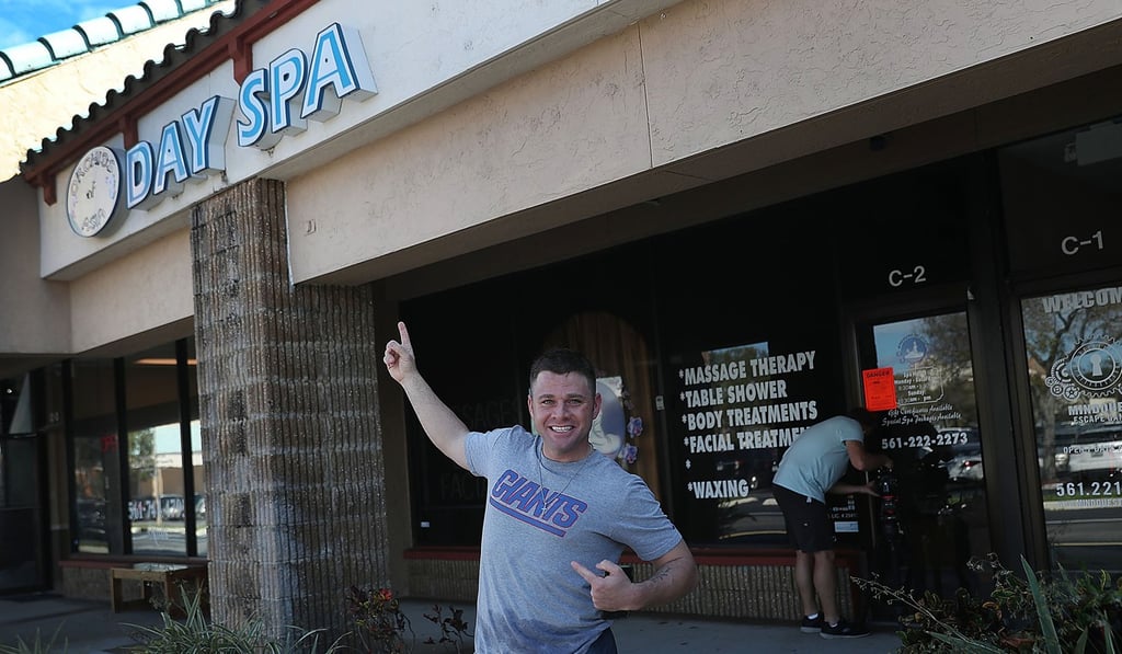 Mark McGuire, a New York Giants football fan, poses on Friday in front of the Orchids of Asia Day Spa in Jupiter, Florida, where New England Patriots owner Robert Kraft was allegedly recorded during sex acts with prostitutes. Photo: AFP Mark McGuire, a New York Giants football fan, poses on Friday in front of the Orchids of Asia Day Spa in Jupiter, Florida, where New England Patriots owner Robert Kraft was allegedly recorded during sex acts with prostitutes. Photo: AFP