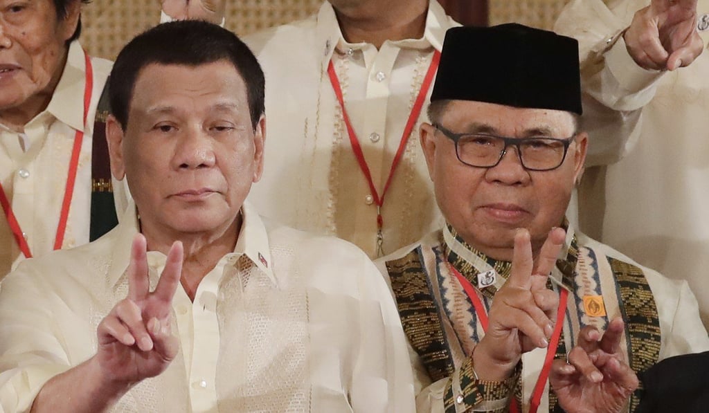 Philippine President Rodrigo Duterte and Moro Islamic Liberation Front chairman Murad Ebrahim flash peace signs at thr oath-taking ceremony for the creation of the Bangsamoro Transition Authority. Photo: AP Philippine President Rodrigo Duterte and Moro Islamic Liberation Front chairman Murad Ebrahim flash peace signs at thr oath-taking ceremony for the creation of the Bangsamoro Transition Authority. Photo: AP