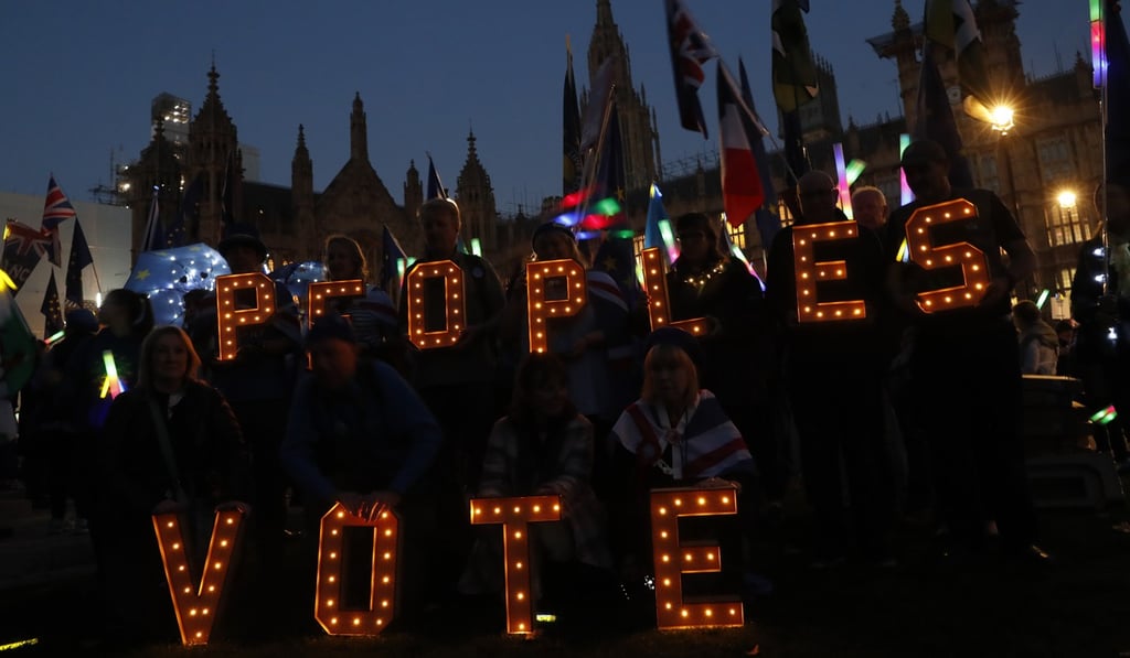 Anti-Brexit demonstrators hold up a sign seeking a “People's Vote” opposite the Houses of Parliament in London on Wednesday. Photo: AP