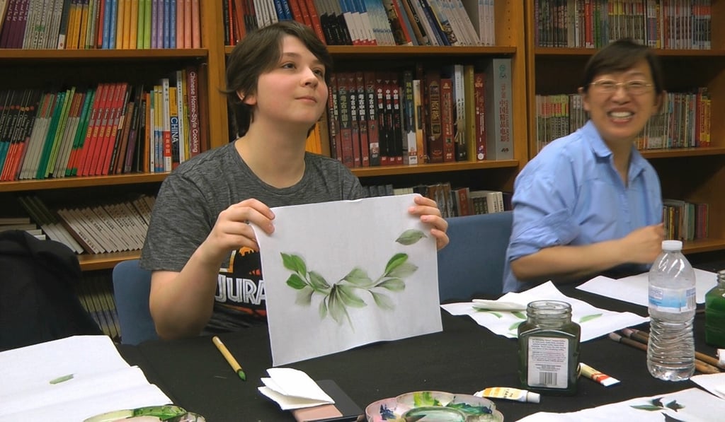 Undergraduate student Moe Lewis, left, shows her watercolour painting of peony leaves at a traditional Chinese painting class at the Confucius Institute at George Mason University in Fairfax, Virginia, on May 2, 2018. Photo: AP