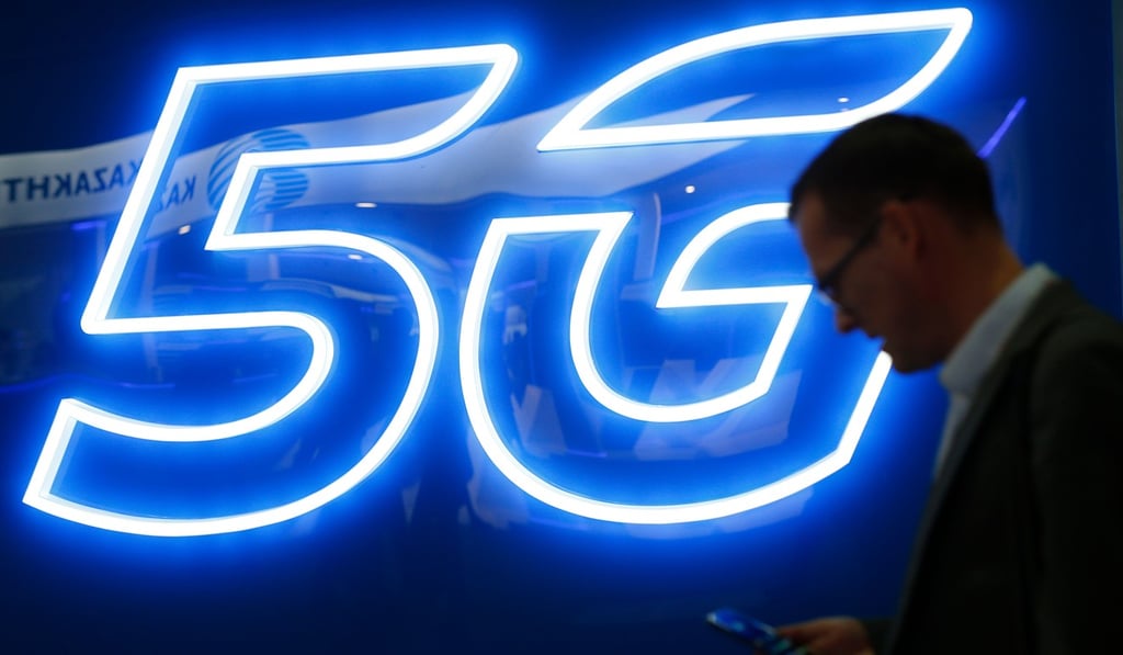 A man uses his phone next to a 5G hotspot sign at the Mobile World Congress in Barcelona, Spain. Photo: AFP A man uses his phone next to a 5G hotspot sign at the Mobile World Congress in Barcelona, Spain. Photo: AFP
