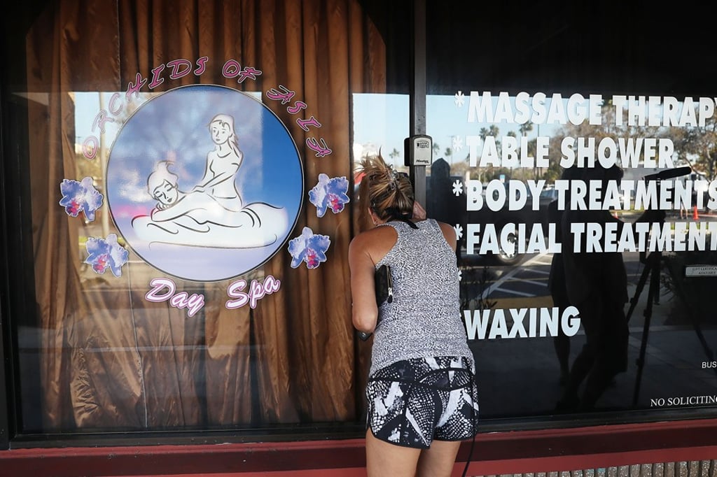 A person looks in a window of the Orchids of Asia Day Spa where New England Patriots owner Robert Kraft allegedly solicited sex. Photo: AFP A person looks in a window of the Orchids of Asia Day Spa where New England Patriots owner Robert Kraft allegedly solicited sex. Photo: AFP