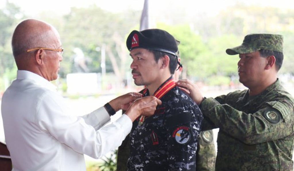Manny Pacquiao receives his medal from defence secretary Delfin Lorenzana at a ceremony in Quezon City. Photo: Wendell Alinia Manny Pacquiao receives his medal from defence secretary Delfin Lorenzana at a ceremony in Quezon City. Photo: Wendell Alinia
