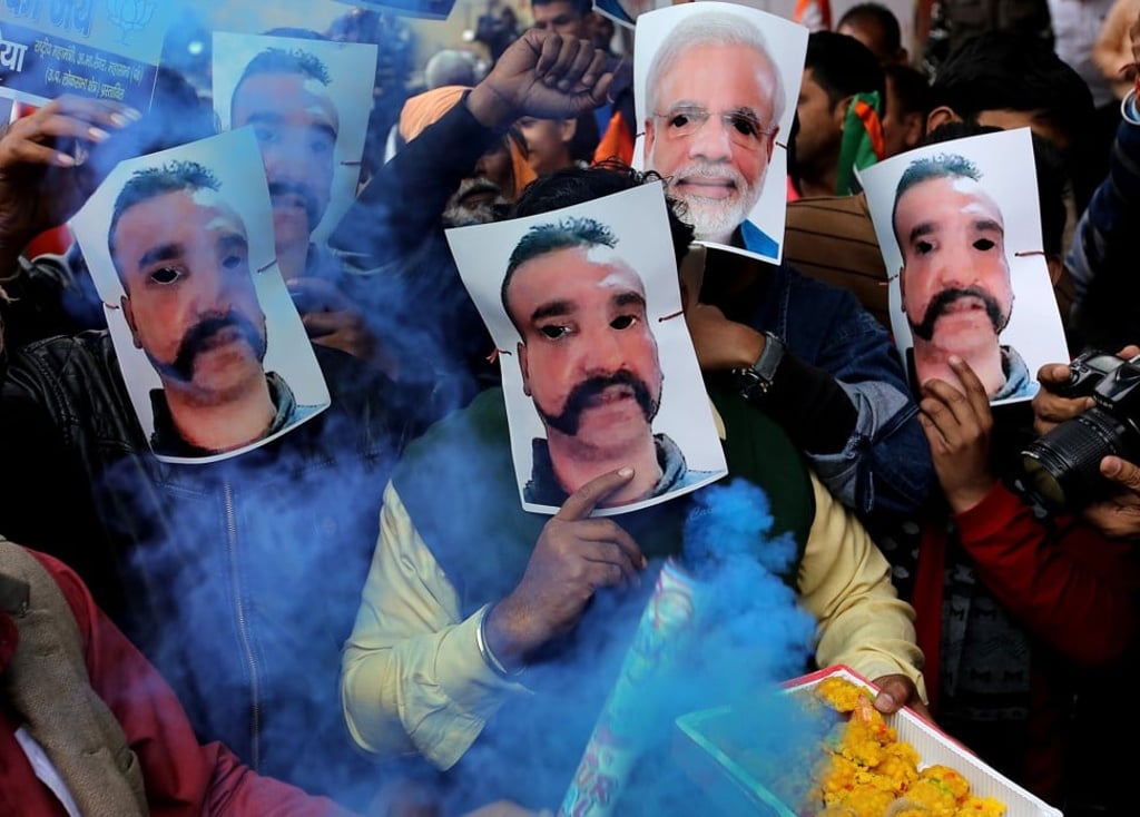 Indian Bhartiya Janata Party (BJP) workers wear masks depicting Indian Prime Minister Narendra Modi and Indian Air Force Wing Commander Abhinandan Varthaman during a bike rally to celebrate Varthaman's return from Pakistan, where he was captured after his jet was shot down. Photo: EPA