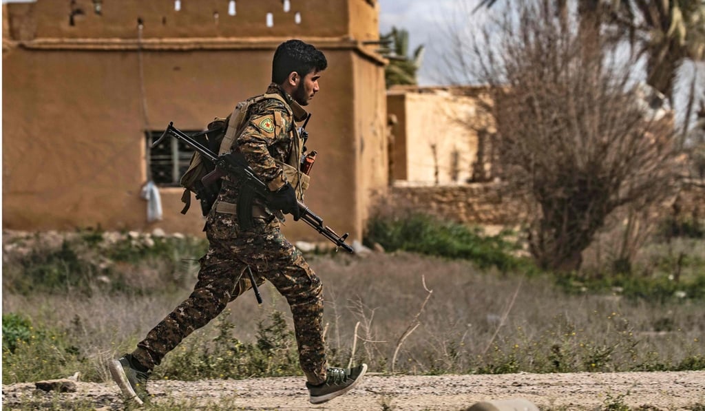 A rebel fighter runs for cover during shelling on the Islamic State group's last holdout of Baghouz on Sunday. Photo: AFP A rebel fighter runs for cover during shelling on the Islamic State group's last holdout of Baghouz on Sunday. Photo: AFP