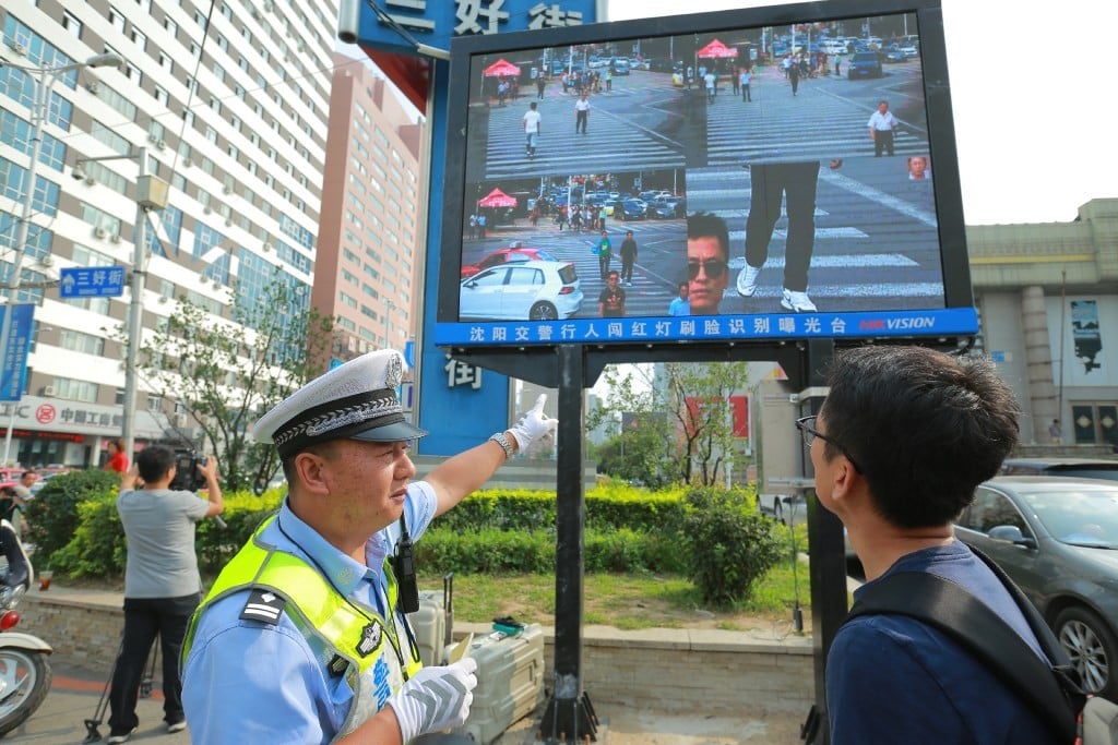 A policeman shows a man that he's been caught jaywalking on a screen besides a road in Shenyang. (Source: China Foto Press) A policeman shows a man that he's been caught jaywalking on a screen besides a road in Shenyang. (Source: China Foto Press)