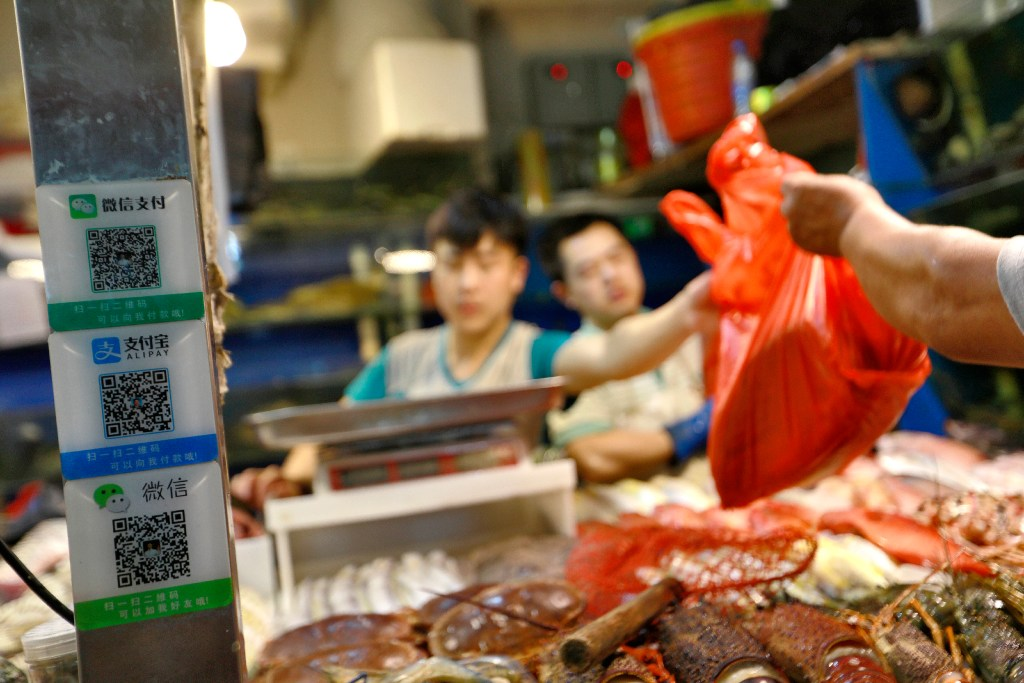 QR codes for WeChat Pay and Alipay at a seafood stall in a market in Beijing. (Picture: How Hwee Young/EPA)