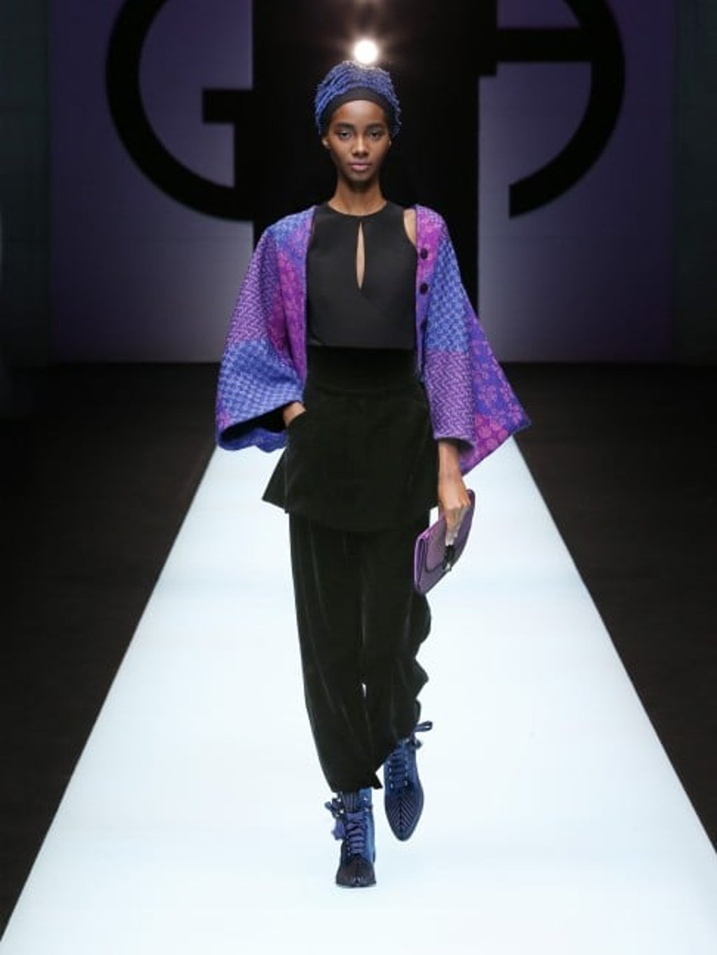 Short blue and purple batwing jacket worn with black peplum top, black velvet trousers, low-heel ankle boots in navy blue satin and half-moon clutch in purple satin.
