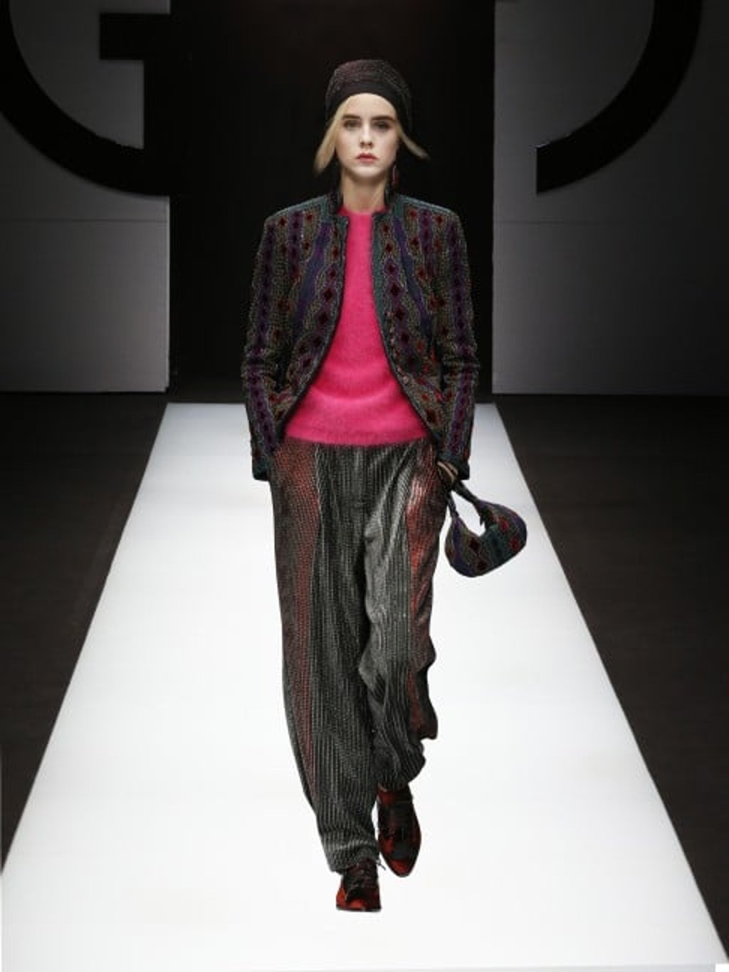 Dazzling evening jacket and trousers with gleaming metallic accents worn with a pink mohair sweater, handbag in multi-coloured patchwork fabric and low-heel, lace-up shoes in burnt orange velvet.