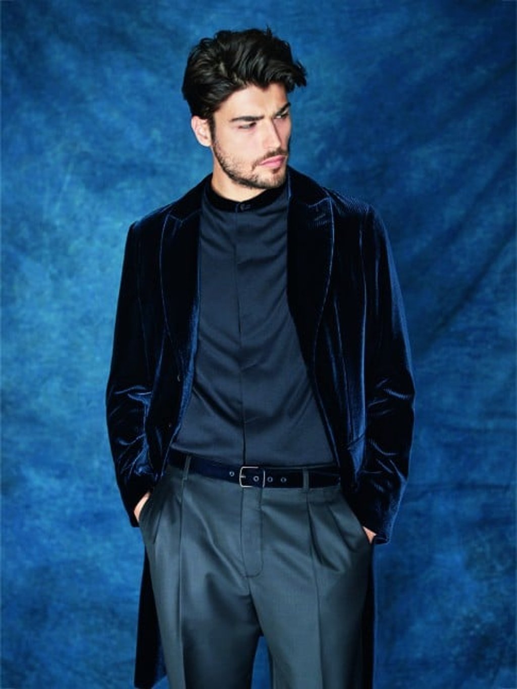 Midnight blue long velvet coat worn over black shirt and trousers.