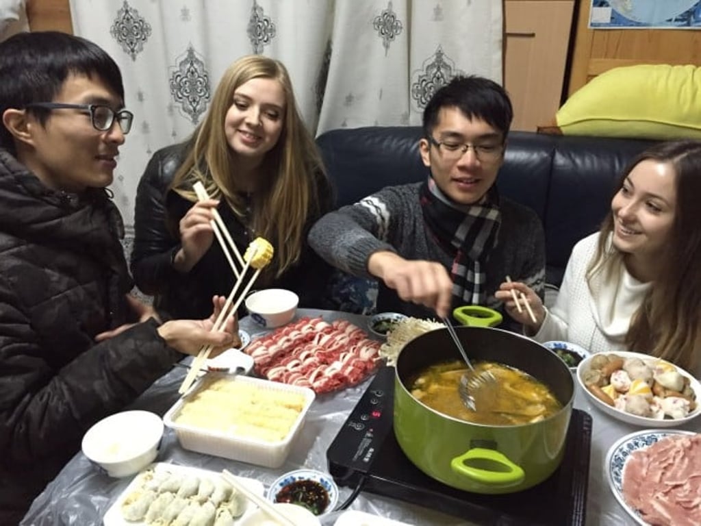 Overseas students enjoy hot pot dinner in a local’s home. Overseas students enjoy hot pot dinner in a local’s home.