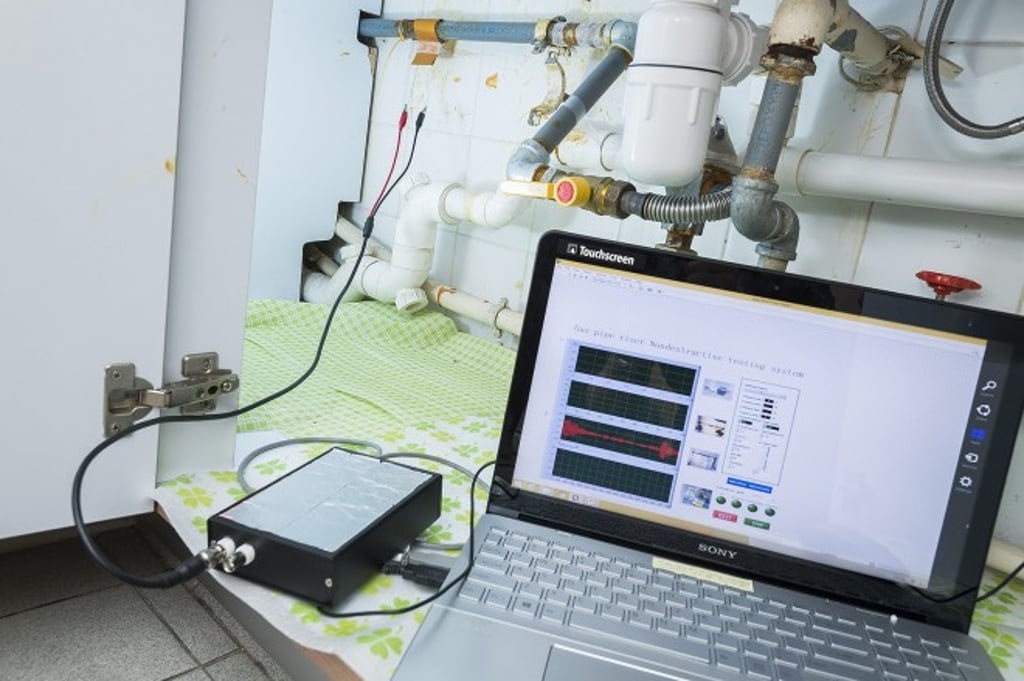 The system developed by the CityU team is shown here examining a gas pipe in the kitchen of a flat. The small box on the left is a USB-based data acquisition box.