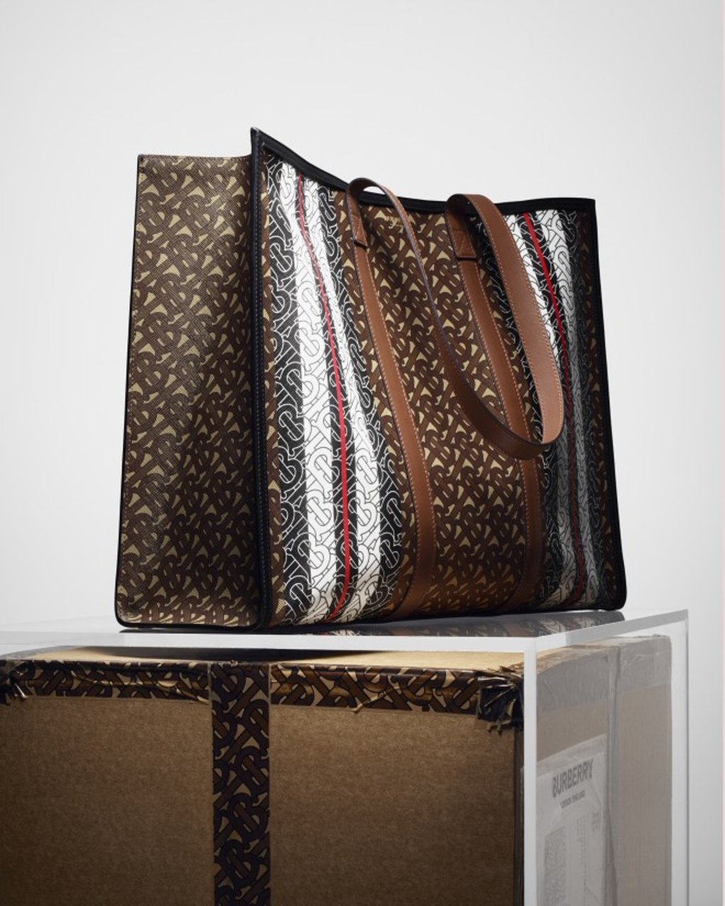 The Burberry Monogram collection tote bag in environmentally conscious e-canvas comes with leather handles.