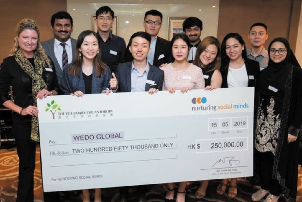 The student team, course instructor and teaching assistant with the “big check” for WEDO Global from The Yeh Family Philanthropy