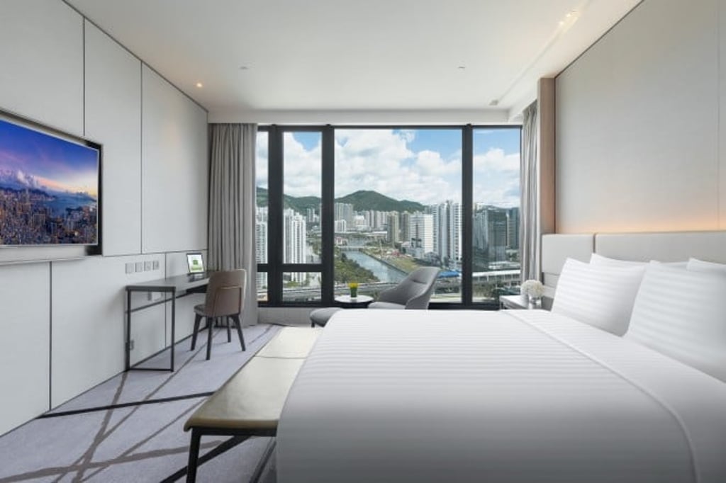 A deluxe room overlooks the Shing Mun River and surrounding cityscape.