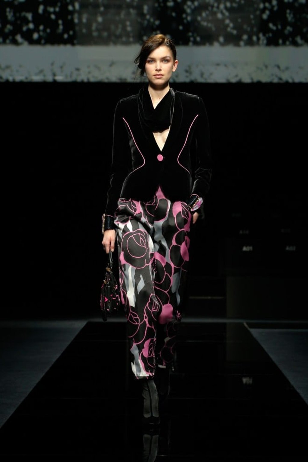 Team a sumptuous black peplum velvet jacket with bows and buttons on the front with a midi organza skirt with black, grey and pink floral patterns for a day-to-evening look.