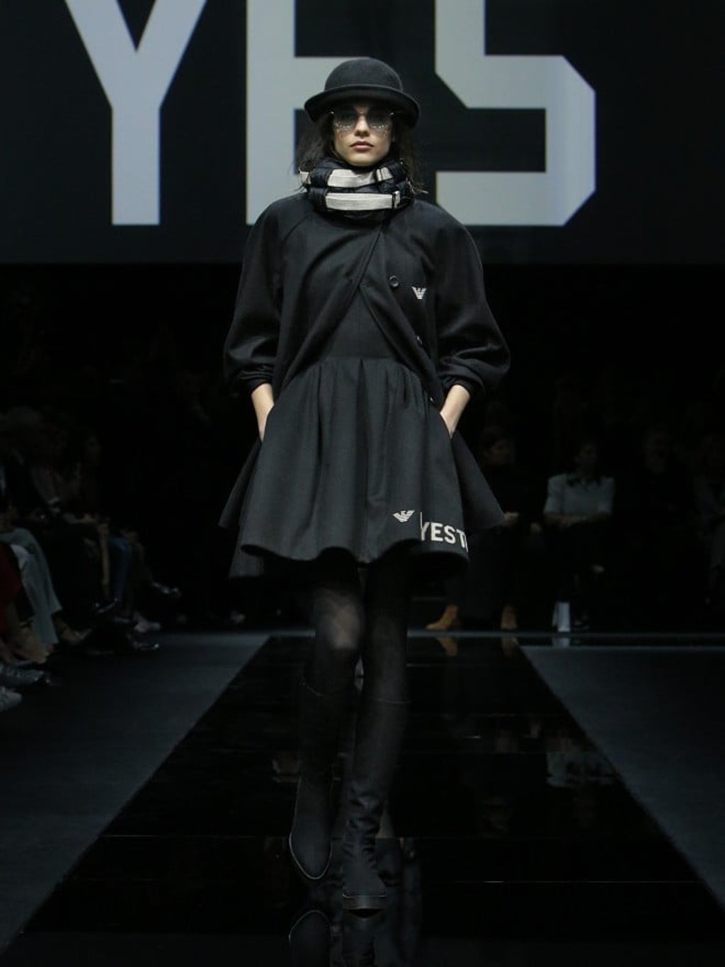 Exude feminine flair while getting the sustainable fashion message across in a short, flared dress worn with double-breasted coat and boots.