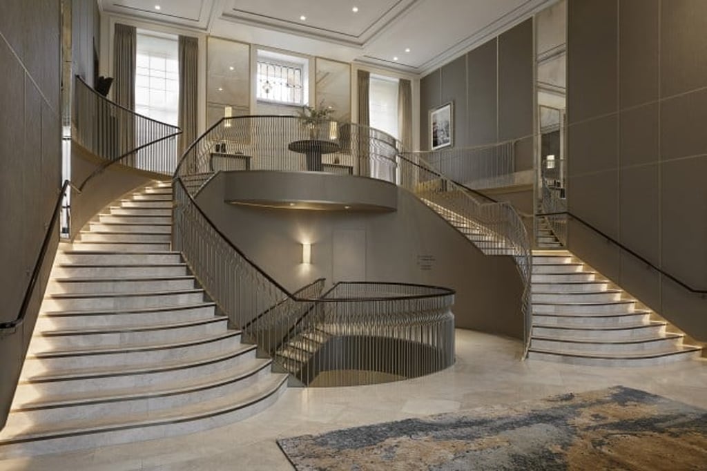 An imperial staircase sweeps down to the concierge desk.