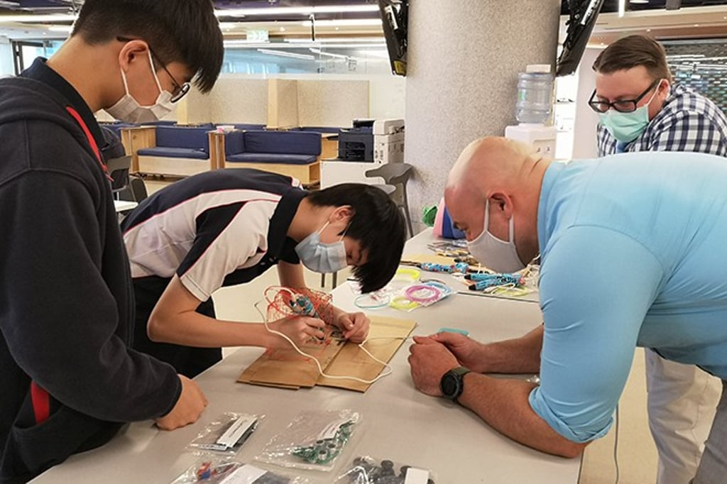 Cornerstone Program Coordinator Tristan Benson working with students on their mock prototype at MIT Hong Kong Innovation Node.