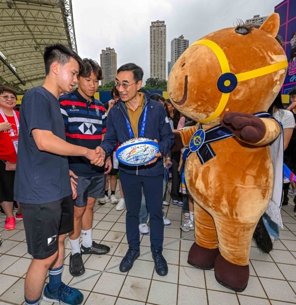 Club Chairman Michael Lee (2nd right) receives a signed rugby ball from young beneficiaries of the Jockey Club Sevens Community Experience as thanks for the Club’s support.