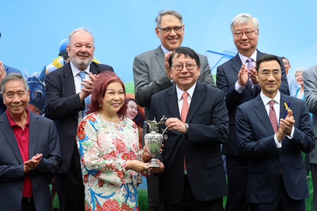 Photo 6: HKSAR Government Chief Secretary for Administration Chan Kwok-ki (front row, 2nd right) presents The Hong Kong Jockey Club Community Trophy to Lyraa Ng (front row, 2nd left), owner of the winning horse Multisuper. The historic 170-year-old trophy was generously donated by the late Mr Tobias Brown in recognition of the Club’s charitable contributions to the community. Photo 6: HKSAR Government Chief Secretary for Administration Chan Kwok-ki (front row, 2nd right) presents The Hong Kong Jockey Club Community Trophy to Lyraa Ng (front row, 2nd left), owner of the winning horse Multisuper. The historic 170-year-old trophy was generously donated by the late Mr Tobias Brown in recognition of the Club’s charitable contributions to the community.