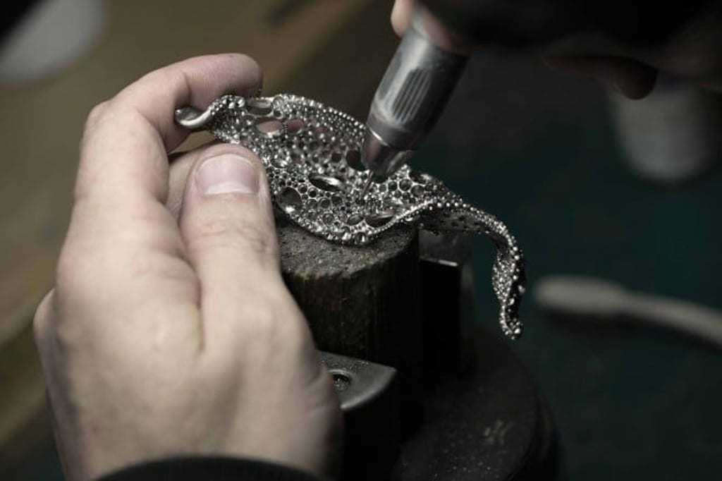 A European master craftsman perfected titanium metalworking on a Four Seasons Leaf brooch, which features an intricate lace-like honeycomb setting. A European master craftsman perfected titanium metalworking on a Four Seasons Leaf brooch, which features an intricate lace-like honeycomb setting.