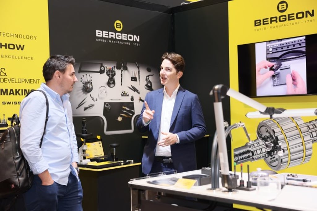 An exhibitor engages with a visitor at the Hong Kong Watch & Clock Fair, where leading names in the watchmaking industry present their expertise.