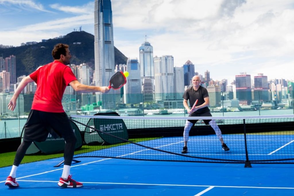 Tennis legend Andre Agassi (right) plays a friendly match against the city’s skyline as backdrop.