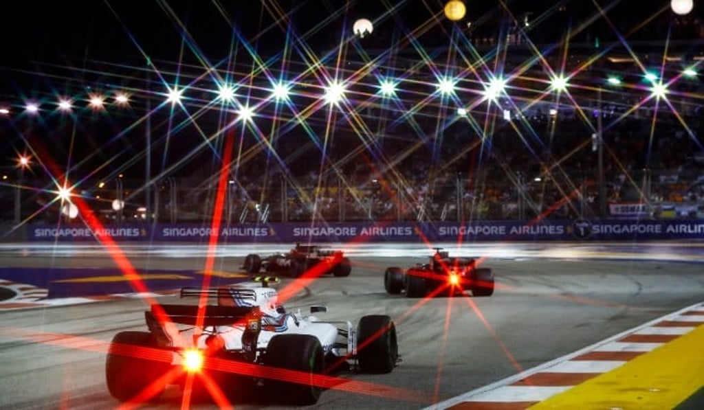 The F1 cars sparkle under the lights of the Marina Bay Street Circuit