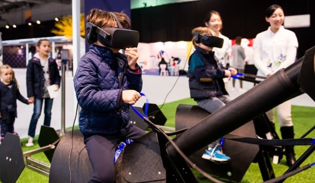 Youngsters wear virtual-reality goggles while enjoying one of the many children’s activities held on the sidelines of the Longines Masters Hong Kong indoor showjumping event. Photo: Longines Masters of Hong Kong 2018 Youngsters wear virtual-reality goggles while enjoying one of the many children’s activities held on the sidelines of the Longines Masters Hong Kong indoor showjumping event. Photo: Longines Masters of Hong Kong 2018