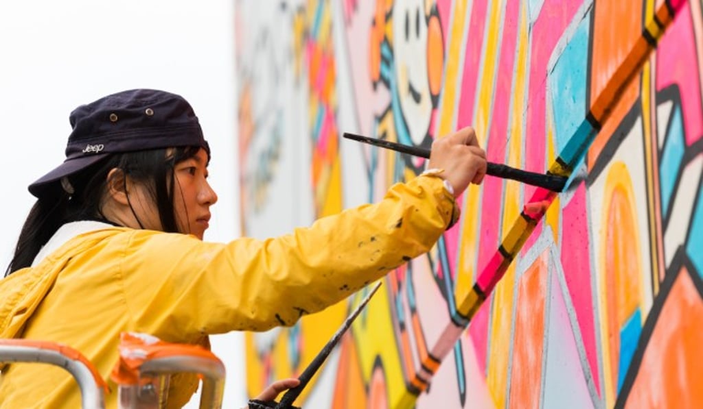Jane Lee, aka Messy Desk, at work on a mural.